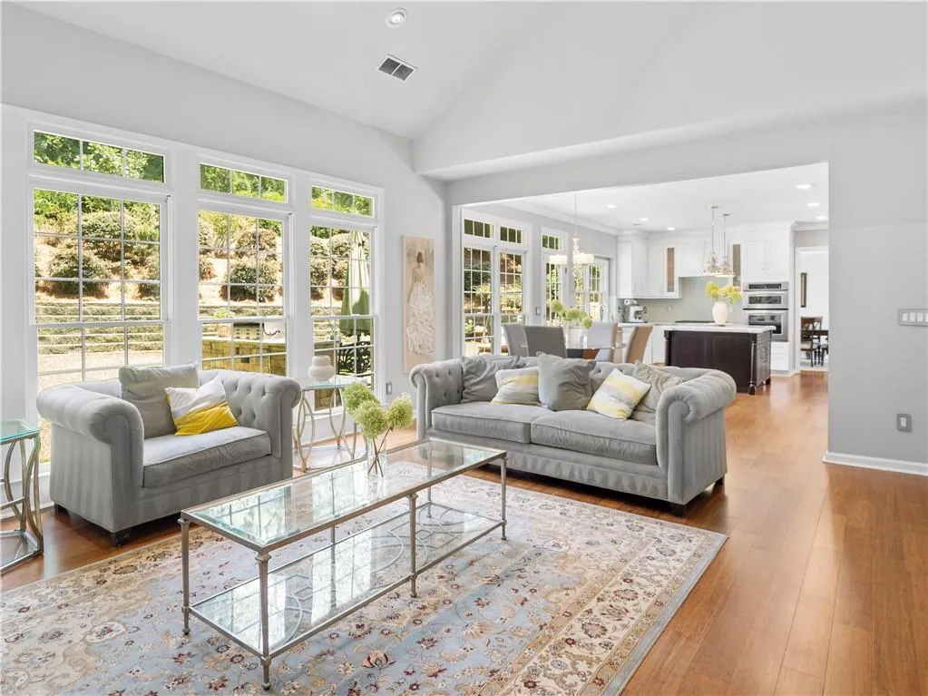 Living room with high vaulted ceiling and light hardwood / wood-style flooring