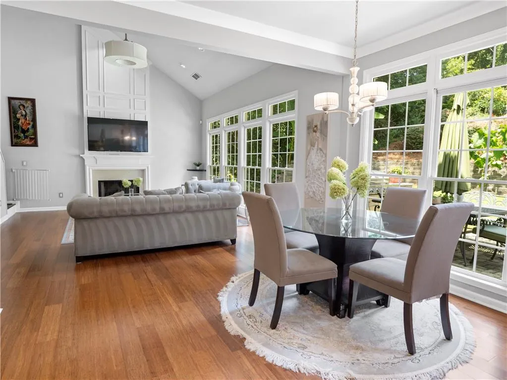 Dining area featuring radiator, high vaulted ceiling, hardwood / wood-style floors, and an inviting chandelier