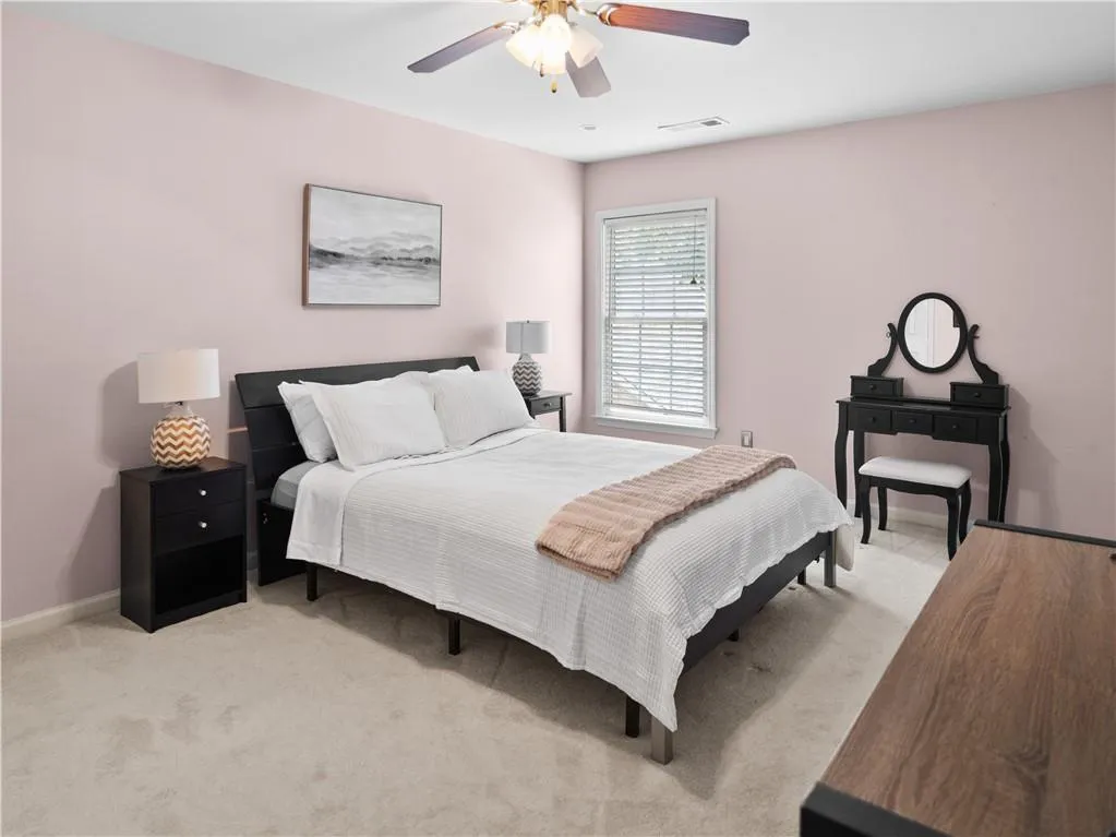 Carpeted bedroom with ceiling fan