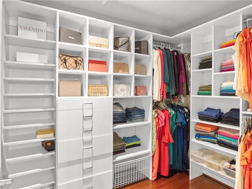 Walk in closet with dark hardwood / wood-style floors