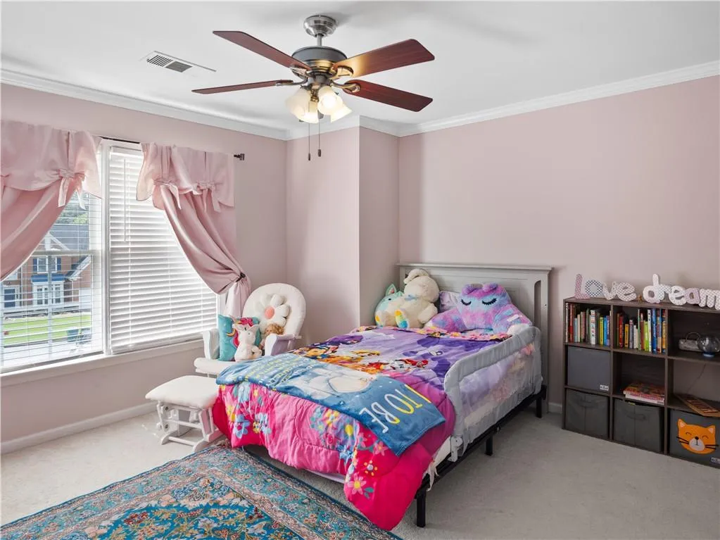 Bedroom featuring carpet, crown molding, and ceiling fan