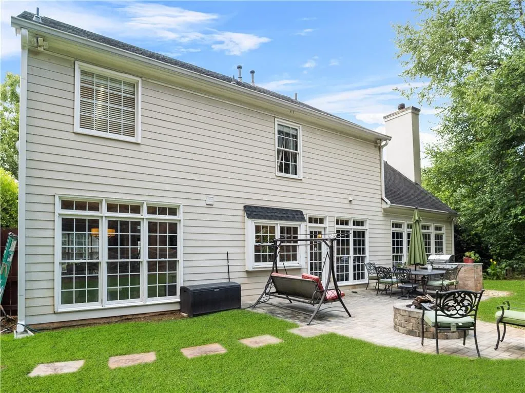 Rear view of property with a lawn and a patio