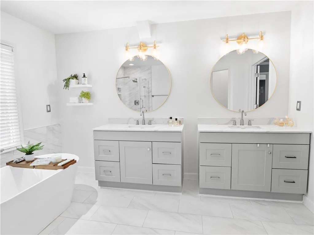 Bathroom featuring double sink vanity, tile patterned floors, and a bath