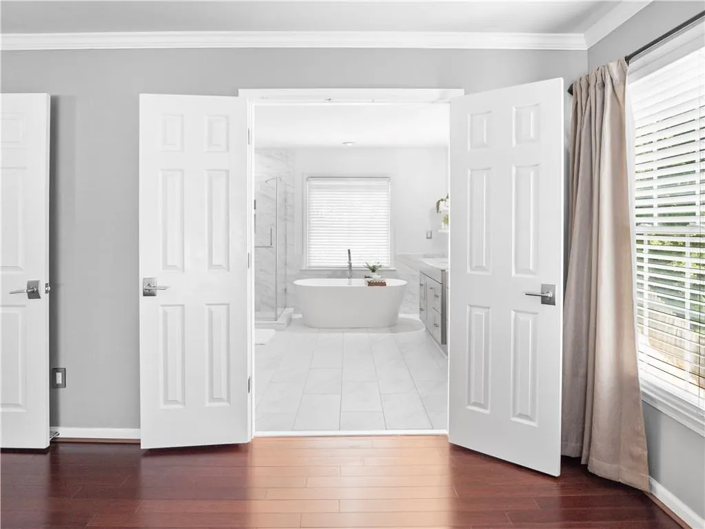 Bathroom with vanity, crown molding, a bathing tub, and tile patterned flooring