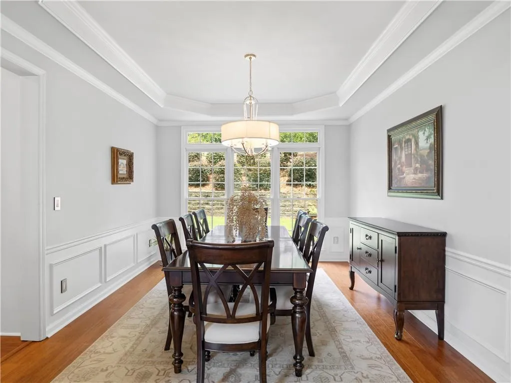 Dining room featuring ornamental molding, light hardwood / wood-style floors, and a tray ceiling