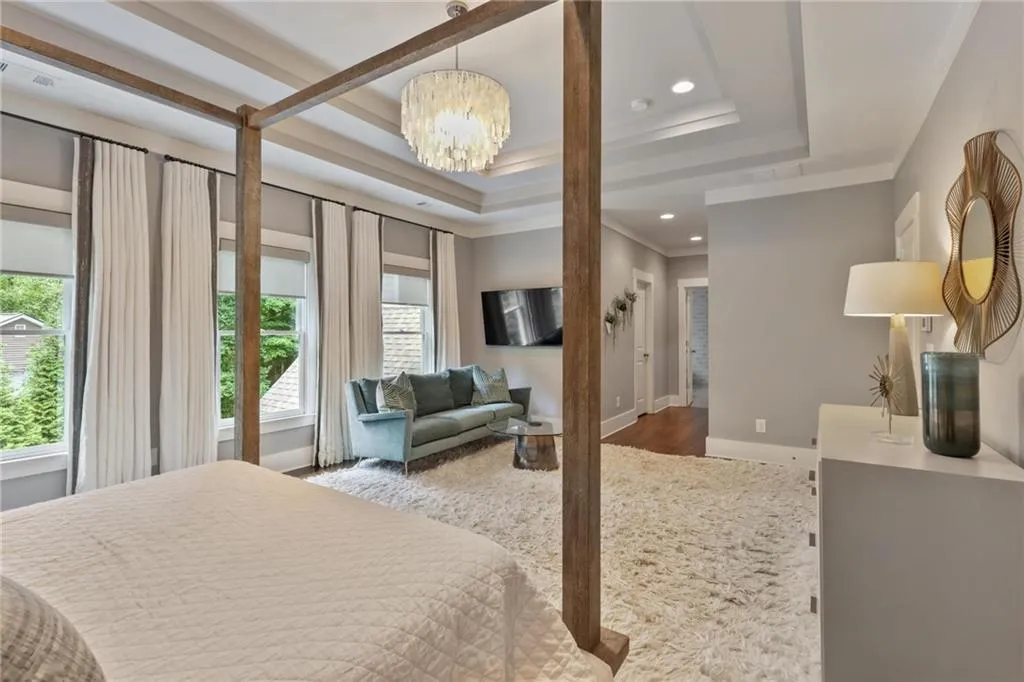 Bedroom featuring crown molding, multiple windows, a tray ceiling, and hardwood / wood-style floors