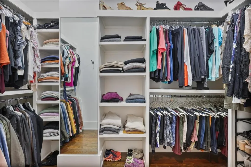Walk in closet with dark hardwood / wood-style flooring
