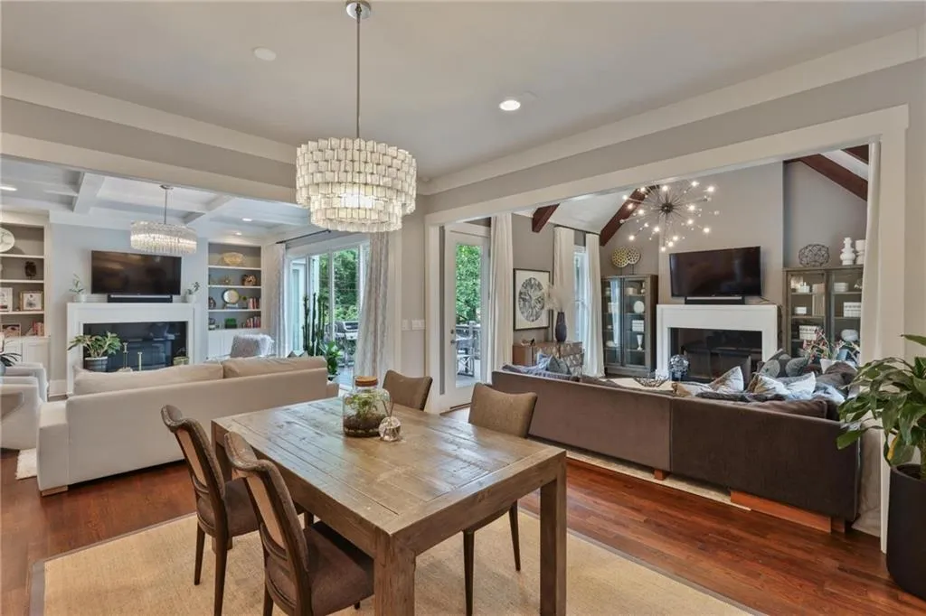 Dining area featuring built in features, dark wood-type flooring, vaulted ceiling with beams, and an inviting chandelier