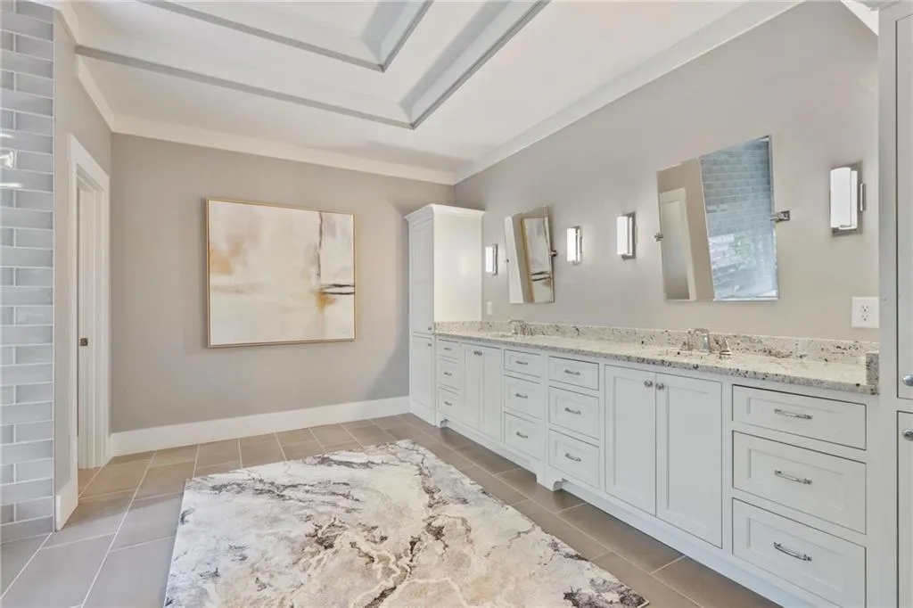 Bathroom featuring dual vanity, tile patterned flooring, and crown molding