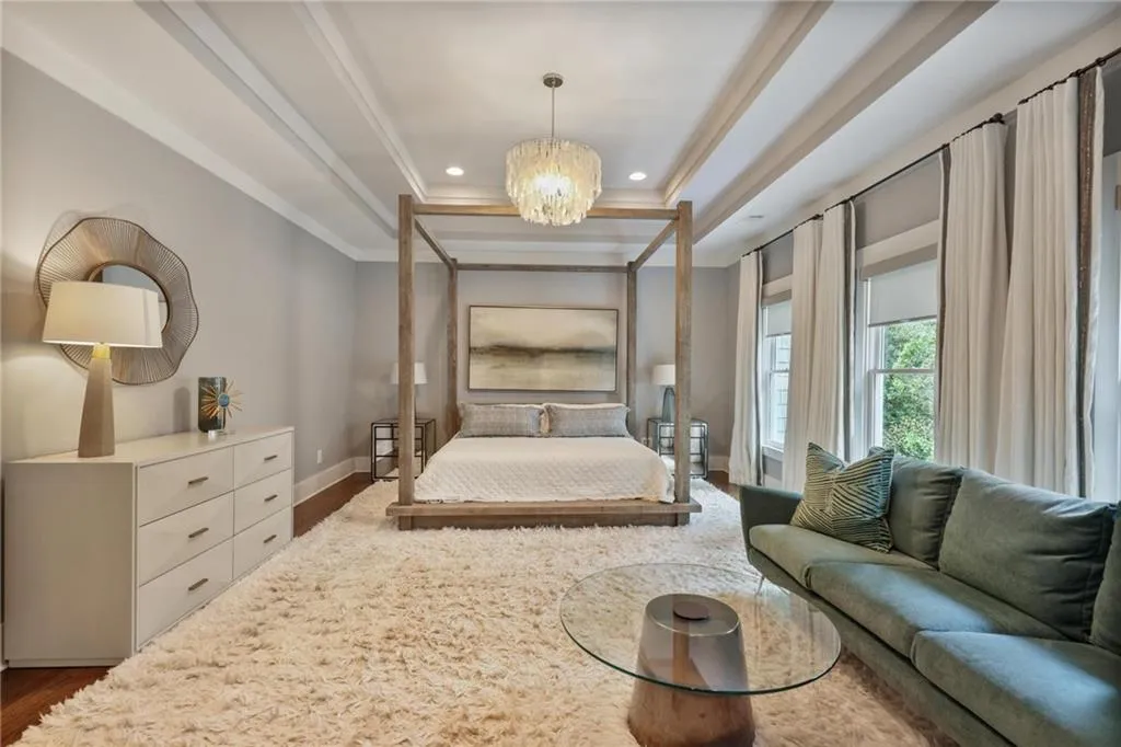 Bedroom featuring crown molding, a chandelier, dark hardwood / wood-style floors, and a tray ceiling