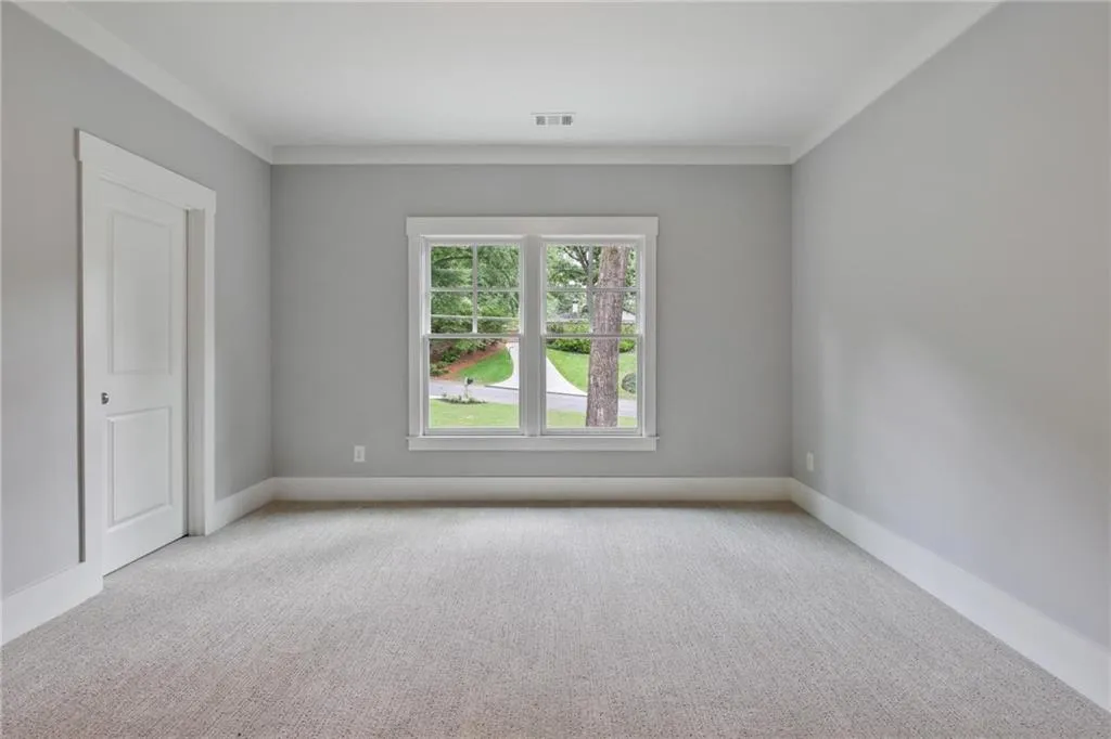 Spare room with crown molding and light carpet