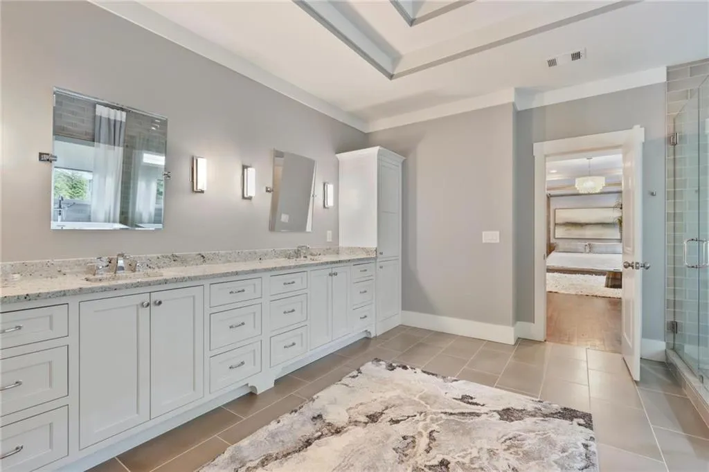 Bathroom with ornamental molding, tile patterned floors, and a shower with door