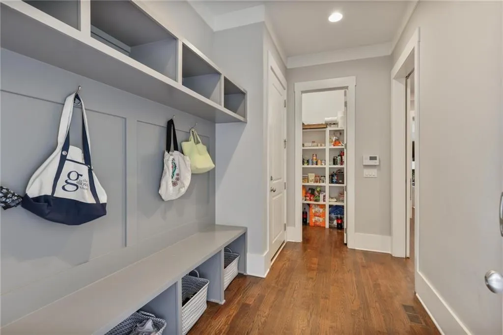 Mudroom with ornamental molding and dark hardwood / wood-style flooring