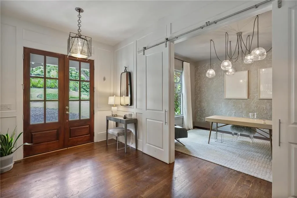 Foyer with an inviting chandelier, a barn door, french doors, and dark hardwood / wood-style floors