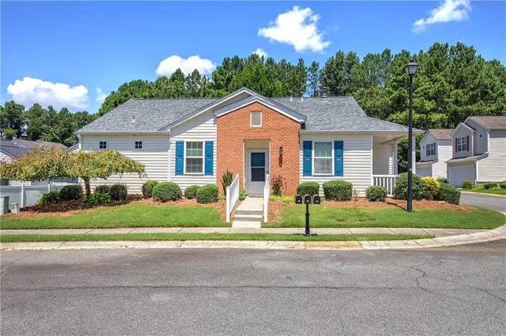 Vinyl Siding exterior featuring a brick facade accent and blue window shutters