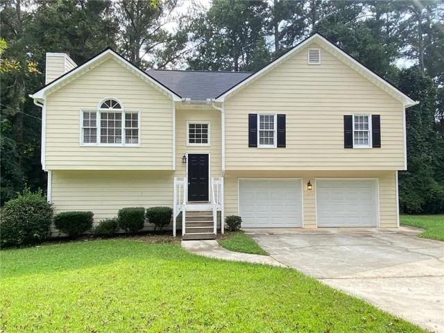 Two-story residence featuring light-colored siding, a dark roof, and a prominent front entrance with white railings