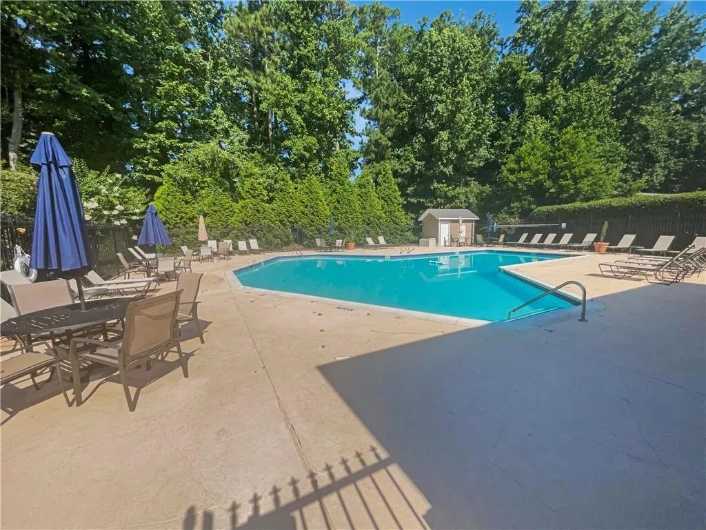 Community pool with a patio area and a shed