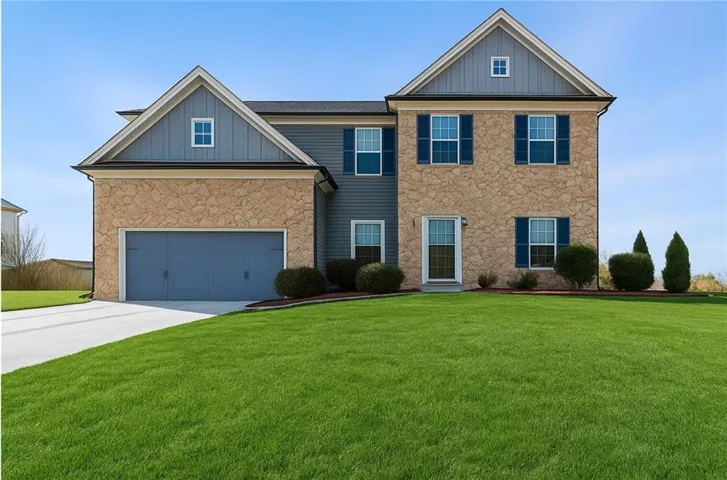 Two-story residence featuring stone and siding facade, a two-car garage, and blue window shutters
