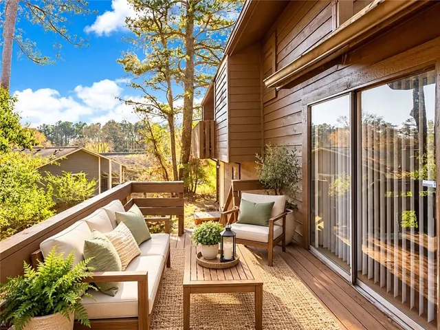 Private balcony featuring wood decking, horizontal siding, sliding glass door, and a wooden railing