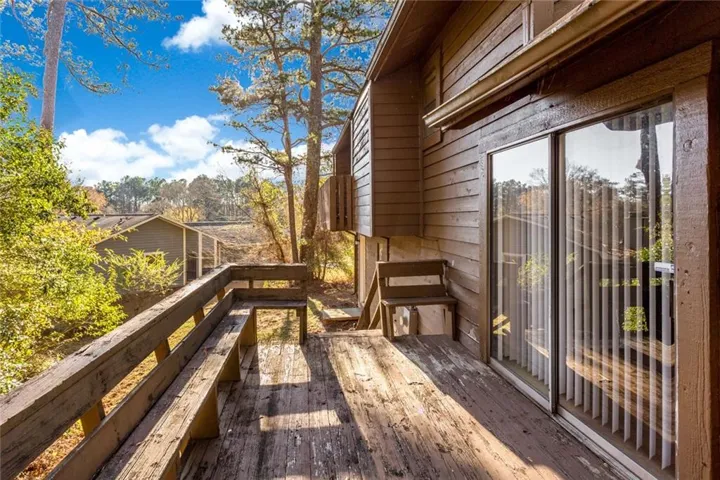 Wood-finish siding with a wood deck featuring integrated seating and a sliding glass door