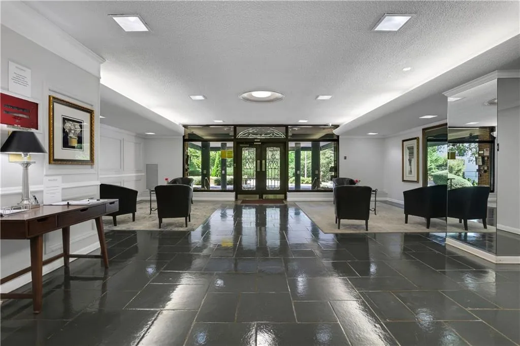 Community lobby with a textured ceiling, ornamental molding, and a wall of windows