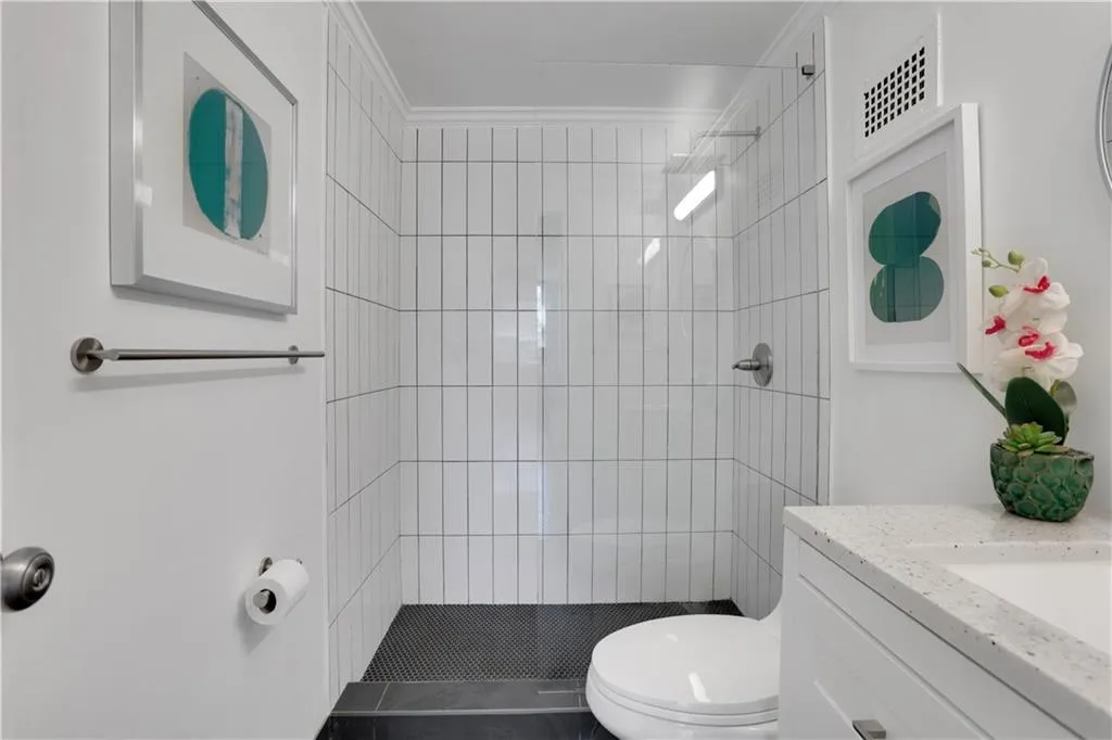 Full bath featuring a stall shower, vanity, and ornamental molding