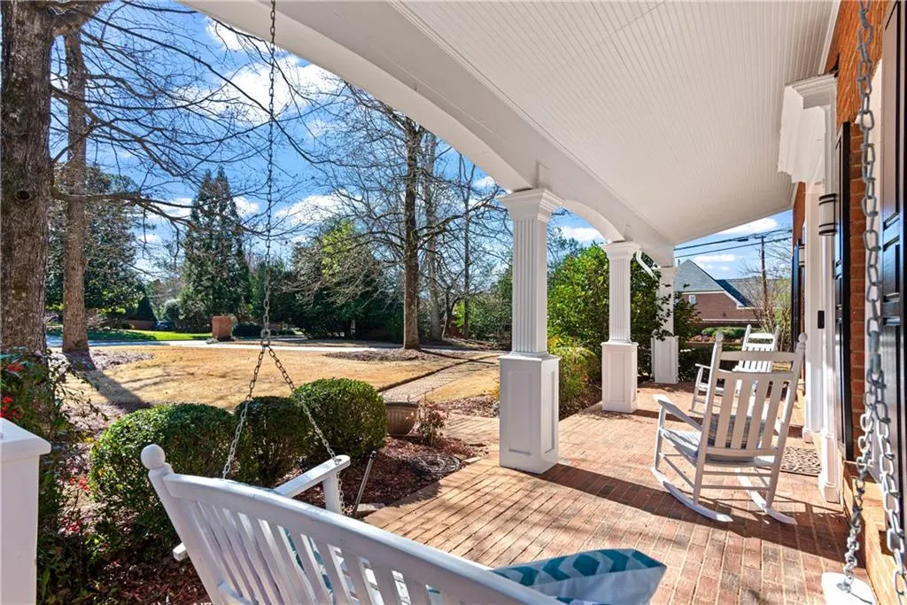 Covered brick porch with room for rocking chairs and swing