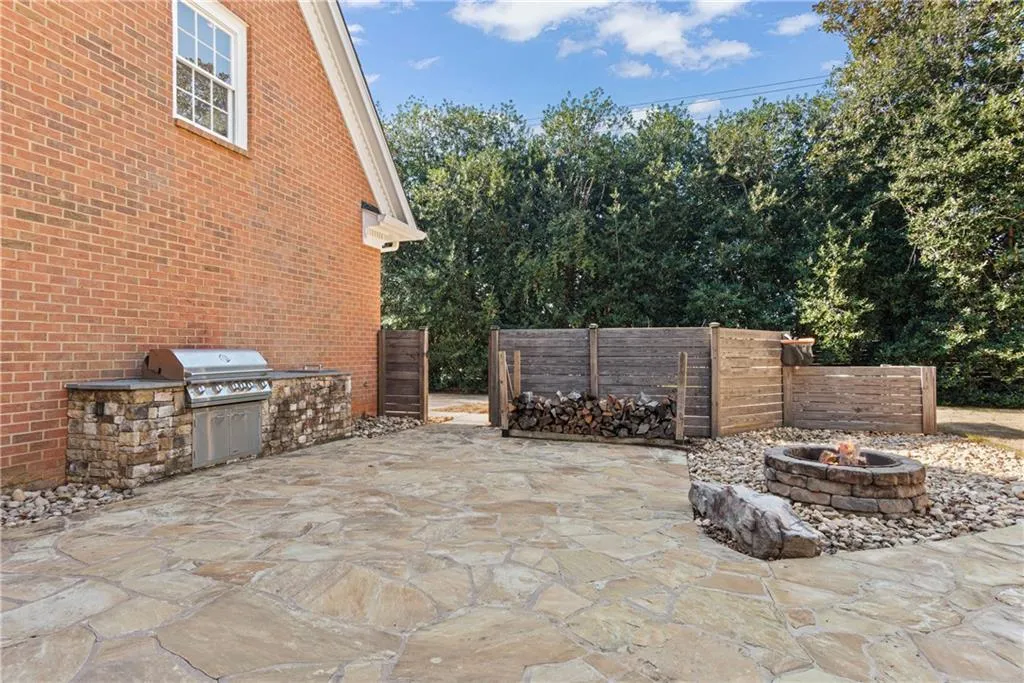 Outdoor grill / kitchen, large flagstone patio, firepit all nicely privatized with natural lush mature landscape and wood privacy fence.