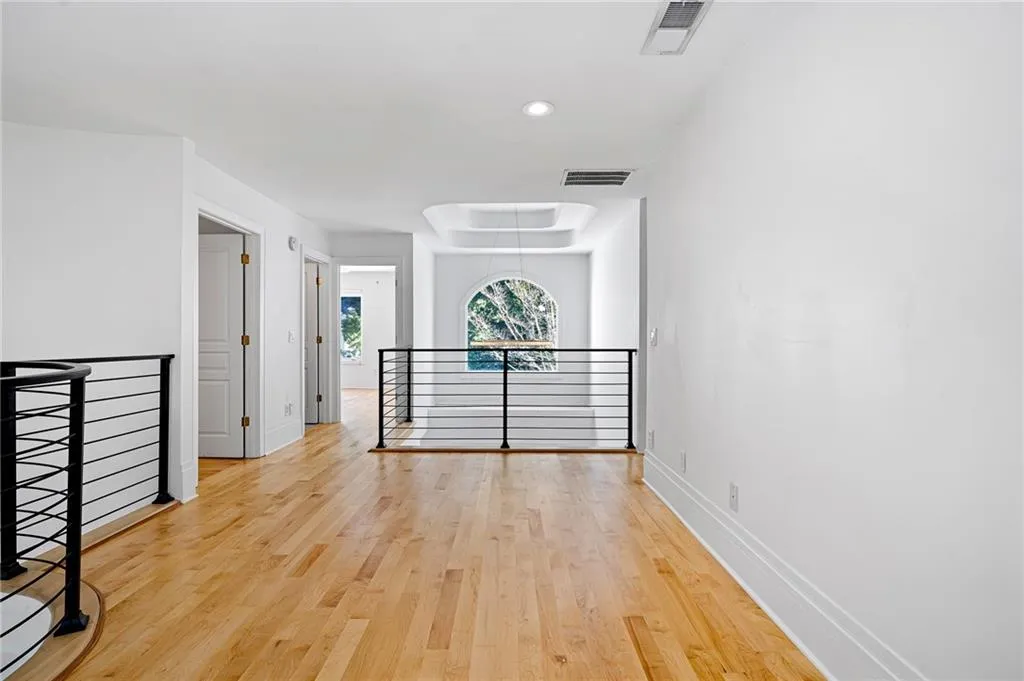 Spare room with light wood-style floors, attic access, and recessed lighting Spare room with light wood-style floors, attic access, and recessed lighting
