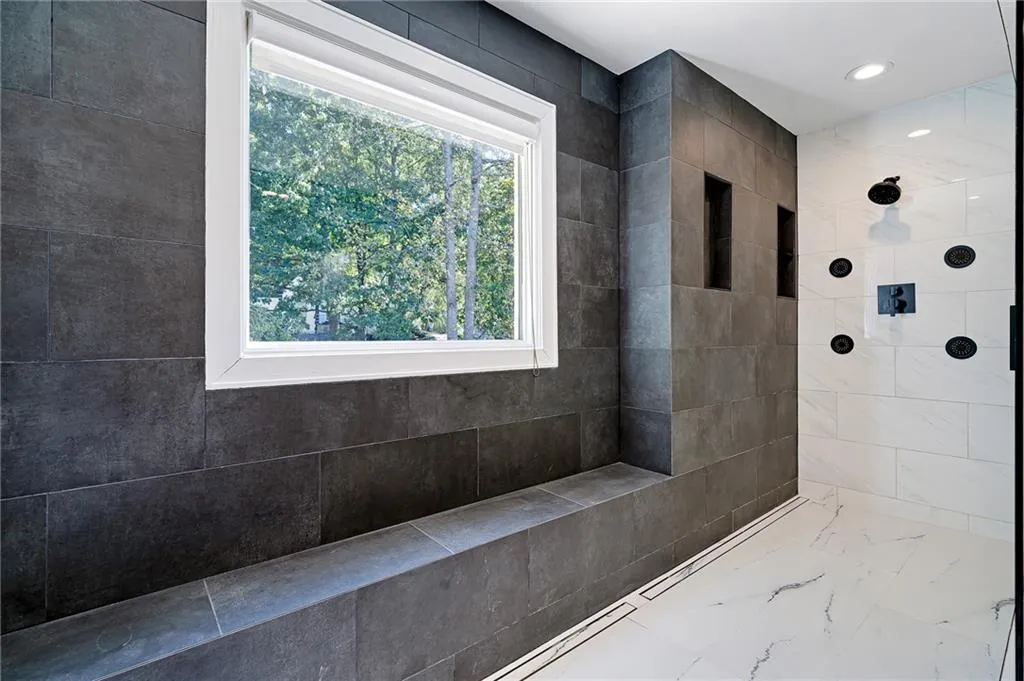 Full bathroom featuring tiled shower, tile walls, marble look tile flooring, and recessed lighting Full bathroom featuring tiled shower, tile walls, marble look tile flooring, and recessed lighting