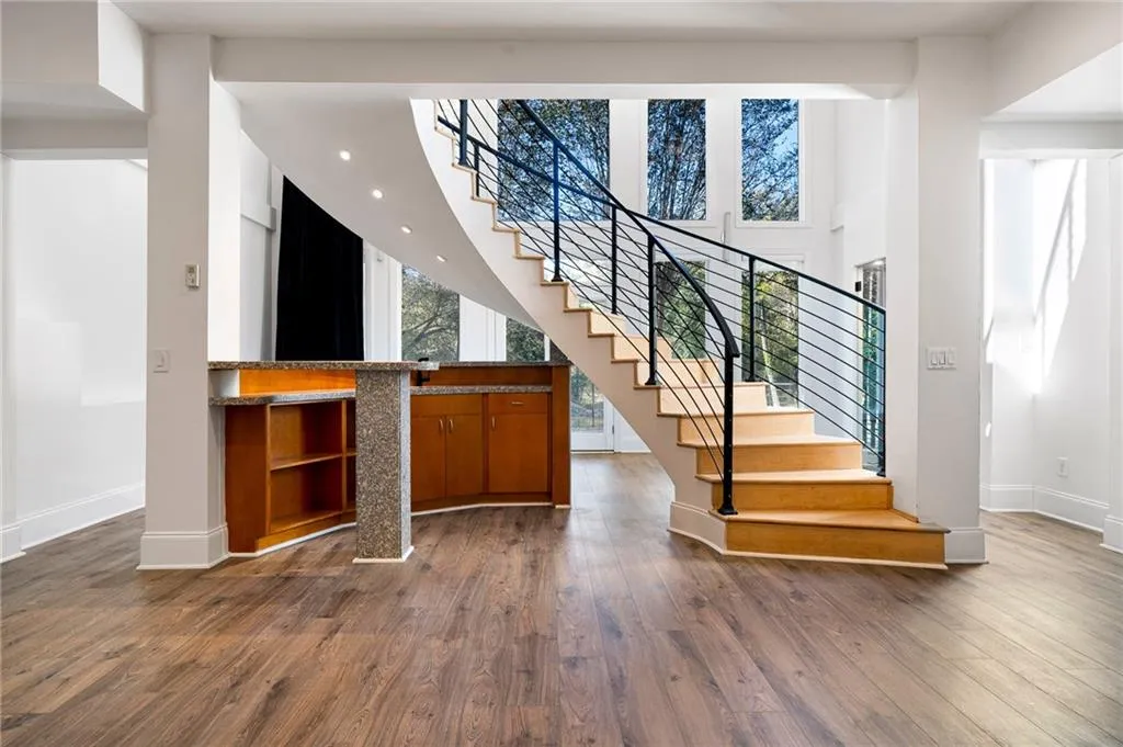 Stairs with healthy amount of natural light, wood finished floors, and a high ceiling Stairs with healthy amount of natural light, wood finished floors, and a high ceiling