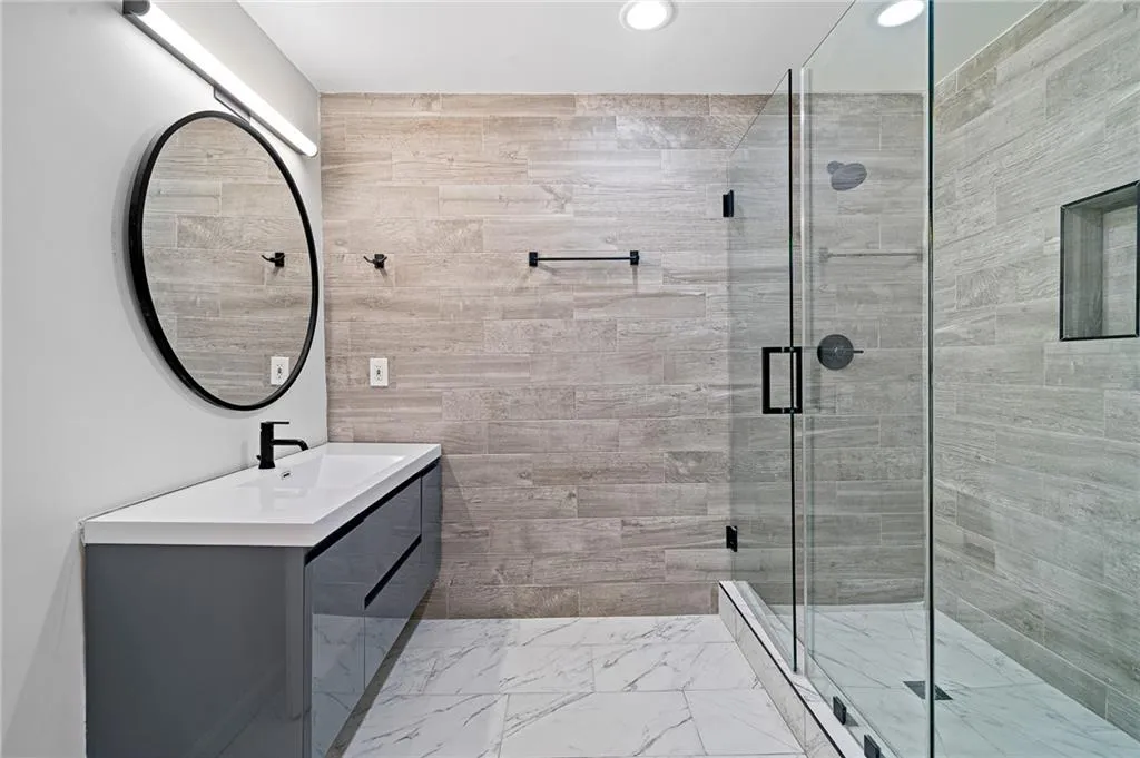 Full bathroom featuring vanity, light marble finish floors, a shower stall, and recessed lighting Full bathroom featuring vanity, light marble finish floors, a shower stall, and recessed lighting