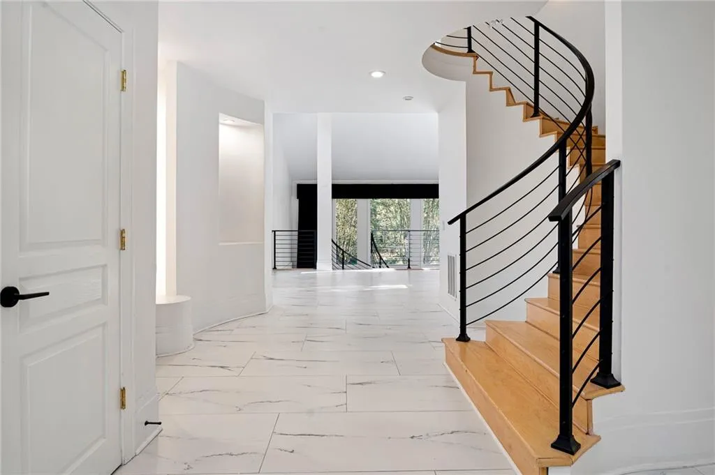 Hall with recessed lighting, light marble finish floors, and stairs Hall with recessed lighting, light marble finish floors, and stairs
