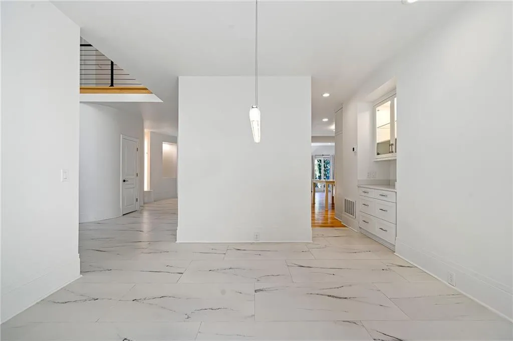 Unfurnished dining area featuring light marble finish flooring and recessed lighting Unfurnished dining area featuring light marble finish flooring and recessed lighting