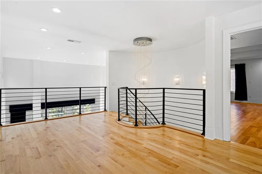 Unfurnished room with a chandelier, light wood-style flooring, and recessed lighting Unfurnished room with a chandelier, light wood-style flooring, and recessed lighting