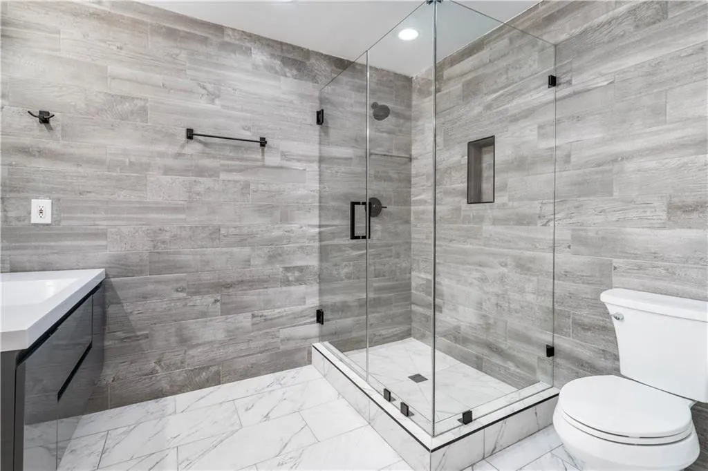Bathroom with vanity, marble look tile flooring, a stall shower, and recessed lighting Bathroom with vanity, marble look tile flooring, a stall shower, and recessed lighting