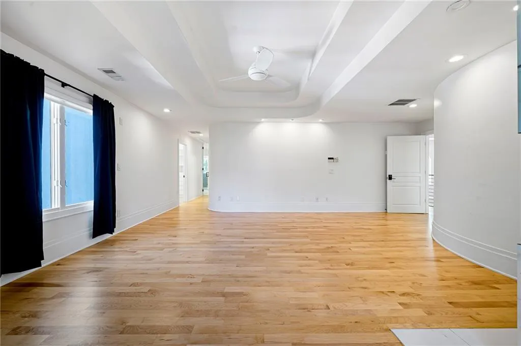 Empty room featuring a tray ceiling, recessed lighting, light wood finished floors, and ceiling fan Empty room featuring a tray ceiling, recessed lighting, light wood finished floors, and ceiling fan