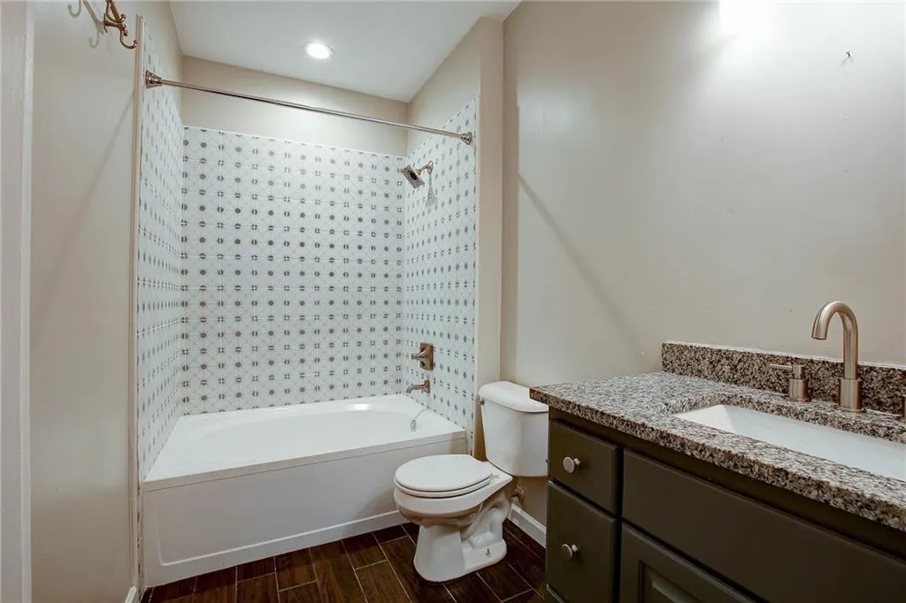 Full bath featuring vanity, shower / bath combination with curtain, and wood tiled floors