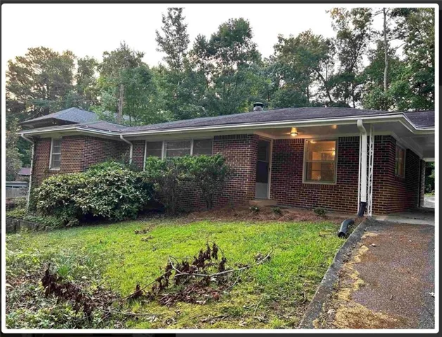 Brick exterior with a covered entryway and a single carport