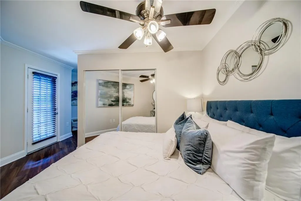 Bedroom with ornamental molding, wood finished floors, and ceiling fan