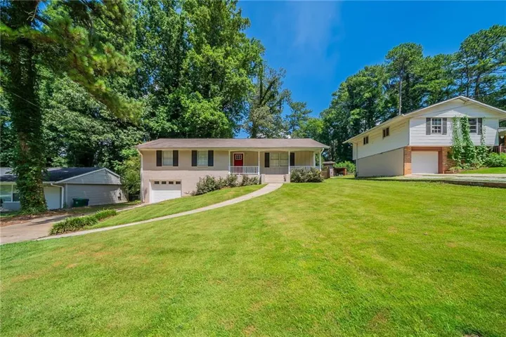 Split-level residence featuring a large front lawn and mature trees
