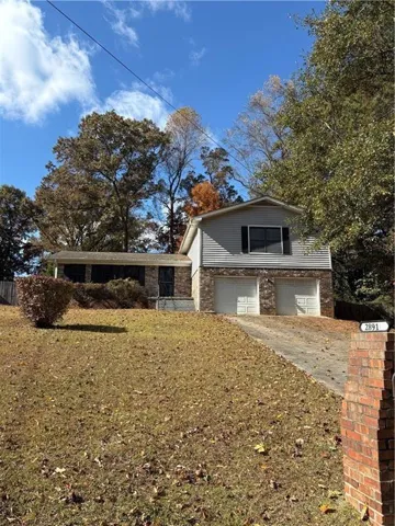 Split-level residence featuring a brick and siding exterior