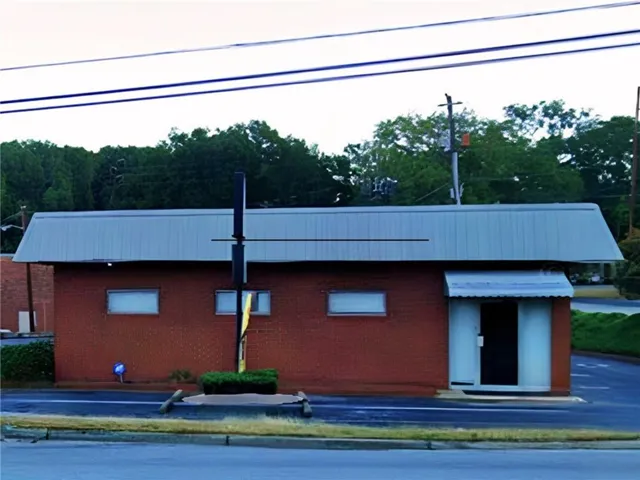 Brick exterior with a metal roof and an entry awning