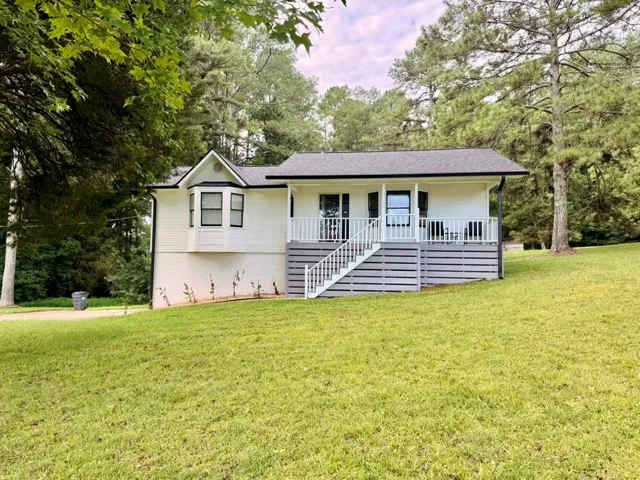 Charming raised ranch home situated on expansive manicured lawn with mature tree backdrop