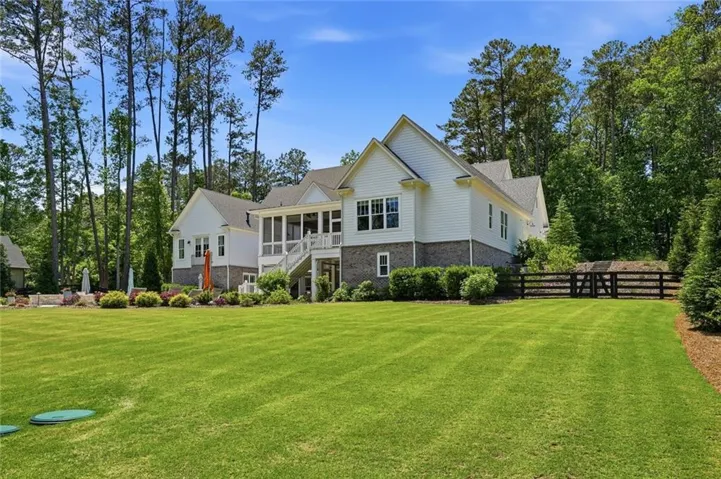 Expansive lawn with mature trees and a privacy fence