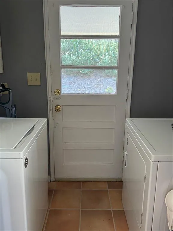Laundry room featuring washer / dryer and light tile patterned flooring