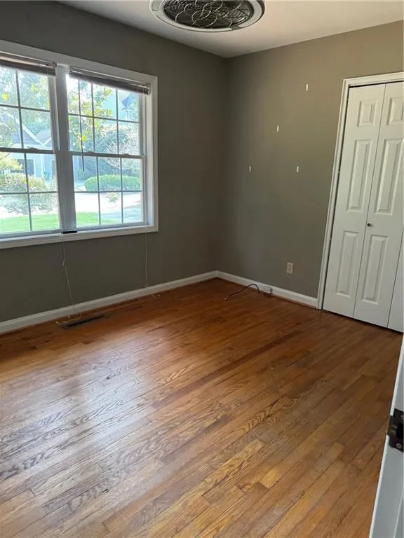 Unfurnished room with hardwood / wood-style floors and baseboards