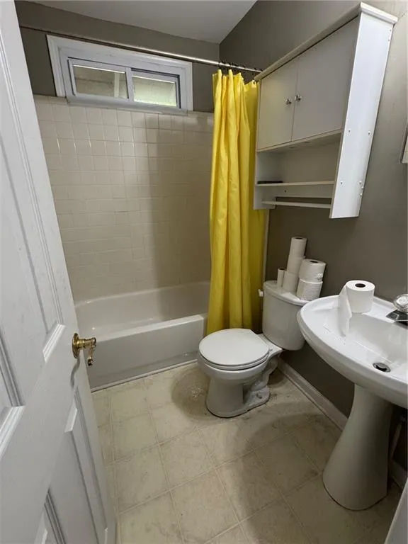 Full bath featuring shower / bath combo and toilet