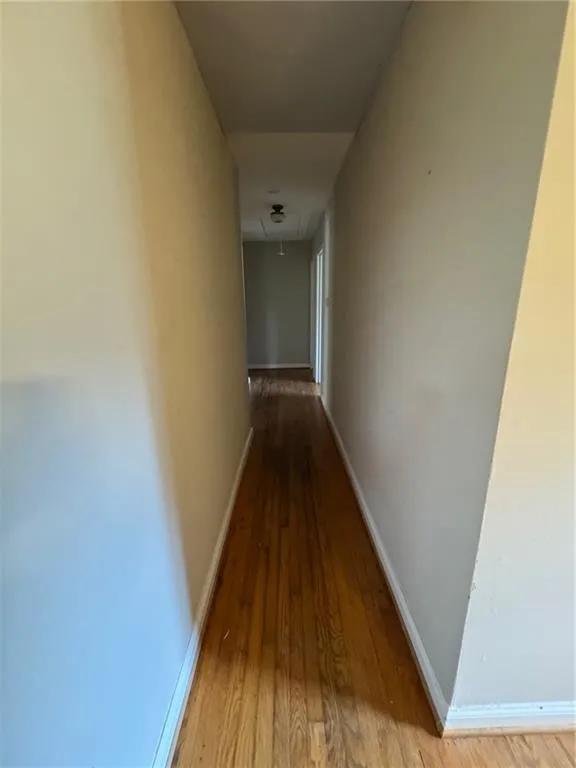 Hallway featuring dark wood-style floors and attic access