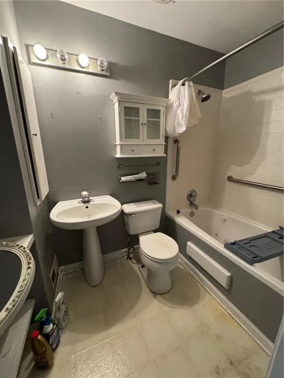 Bathroom with shower / washtub combination and toilet
